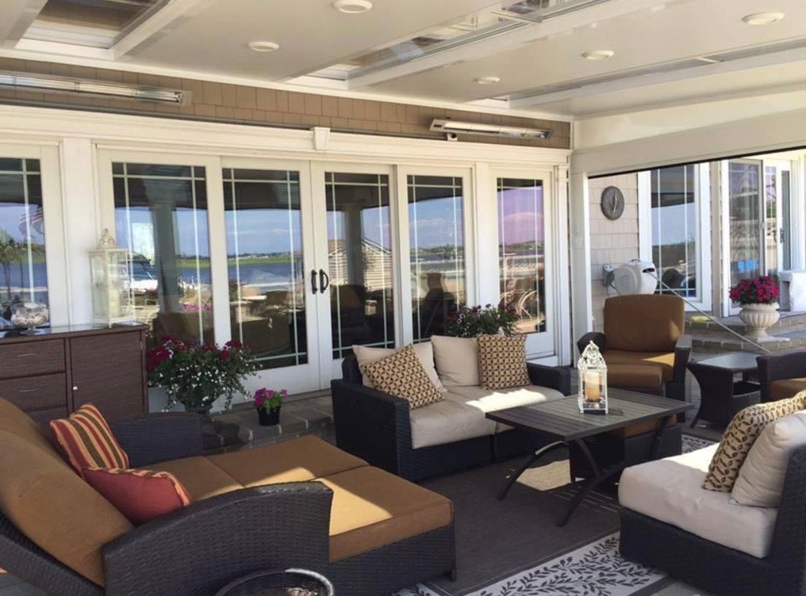 A living room with a lot of furniture and a lot of windows.