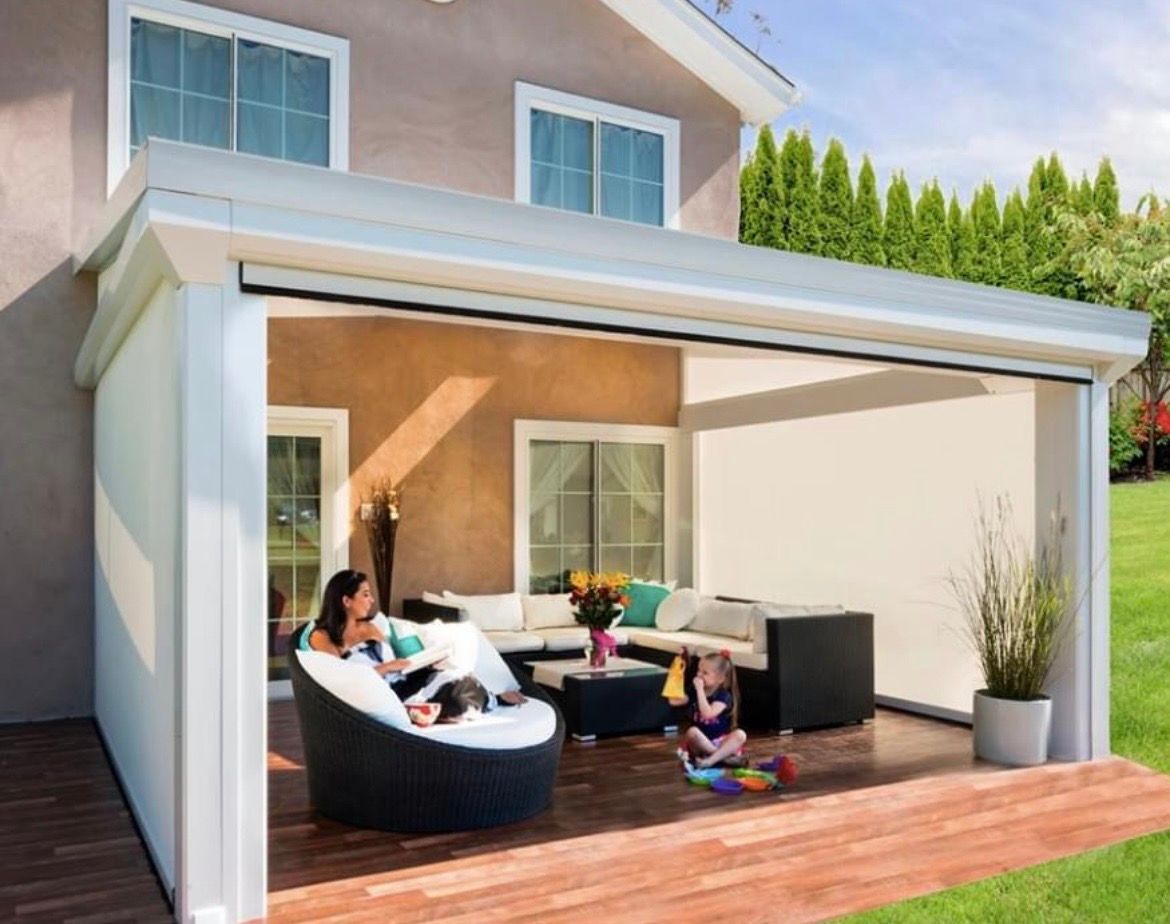 A family is sitting on a patio in front of a house.
