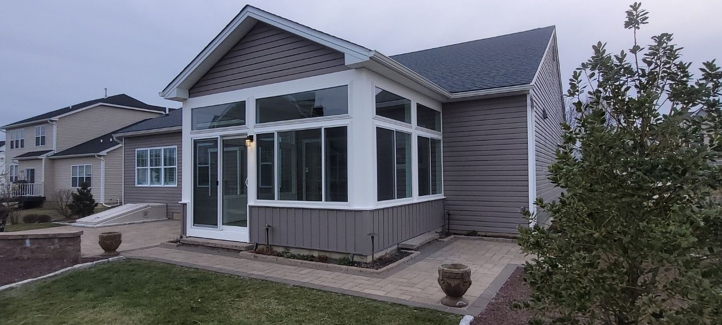 A house with a screened in porch in the backyard.