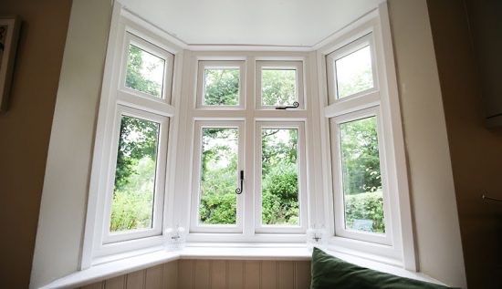 A bay window with a lot of windows in a living room.