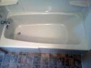 A white bathtub is sitting in a bathroom next to a tiled floor.