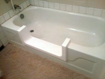A white bathtub with a walk in door in a bathroom.