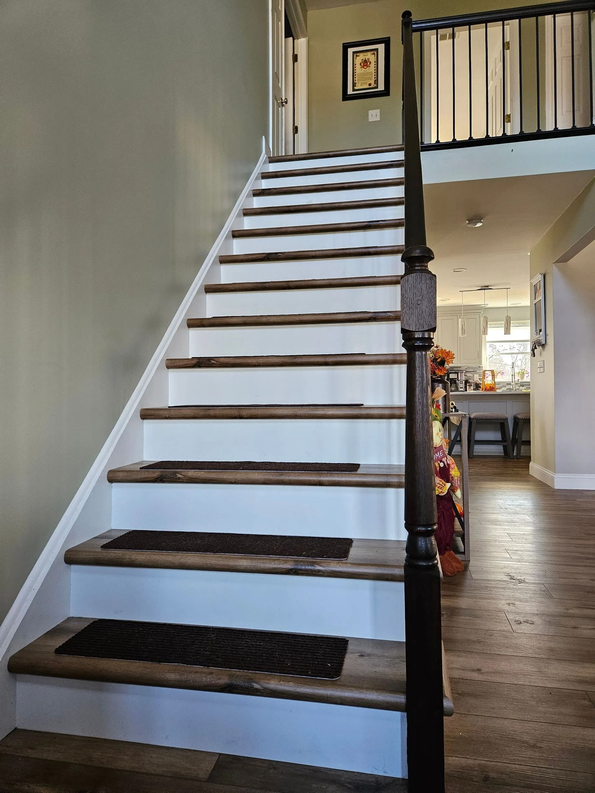 Wooden staircase with white risers and brown treads; a dark wooden banister is visible.