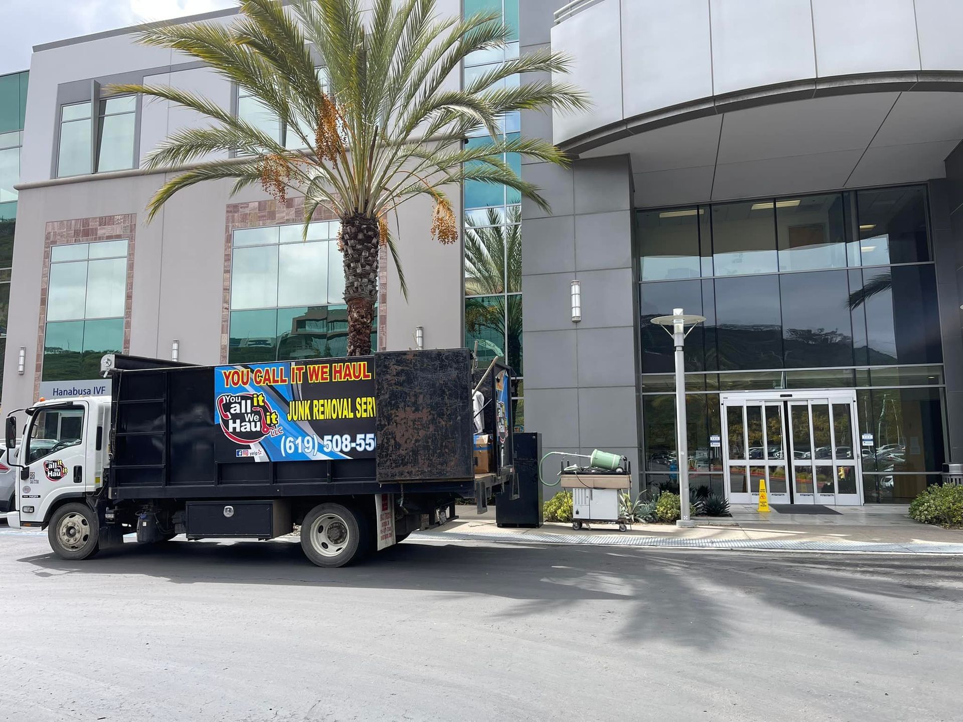 A truck with sound equipment parked near the entrance of a modern building, likely preparing for an event.