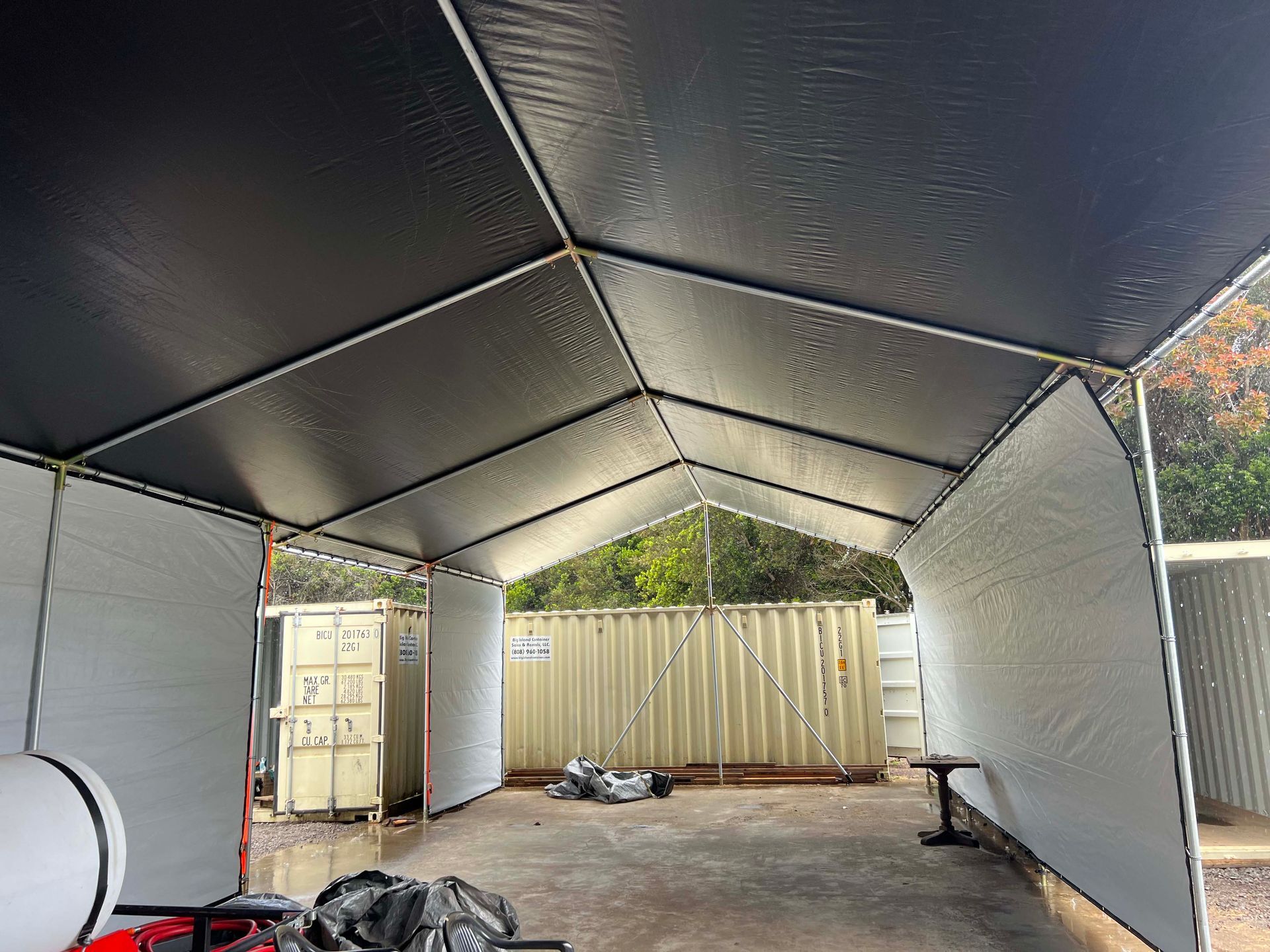 A black and white tent is sitting in a garage.