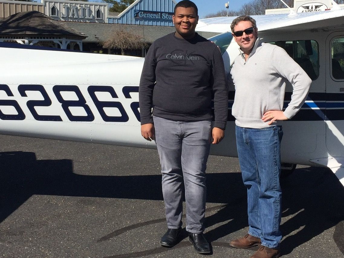 two men are standing in front of a plane
