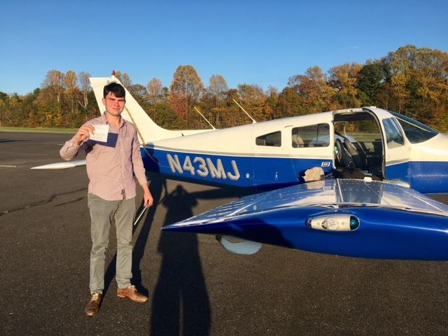 a man is standing in front of a small plane with the letters n43mj on it