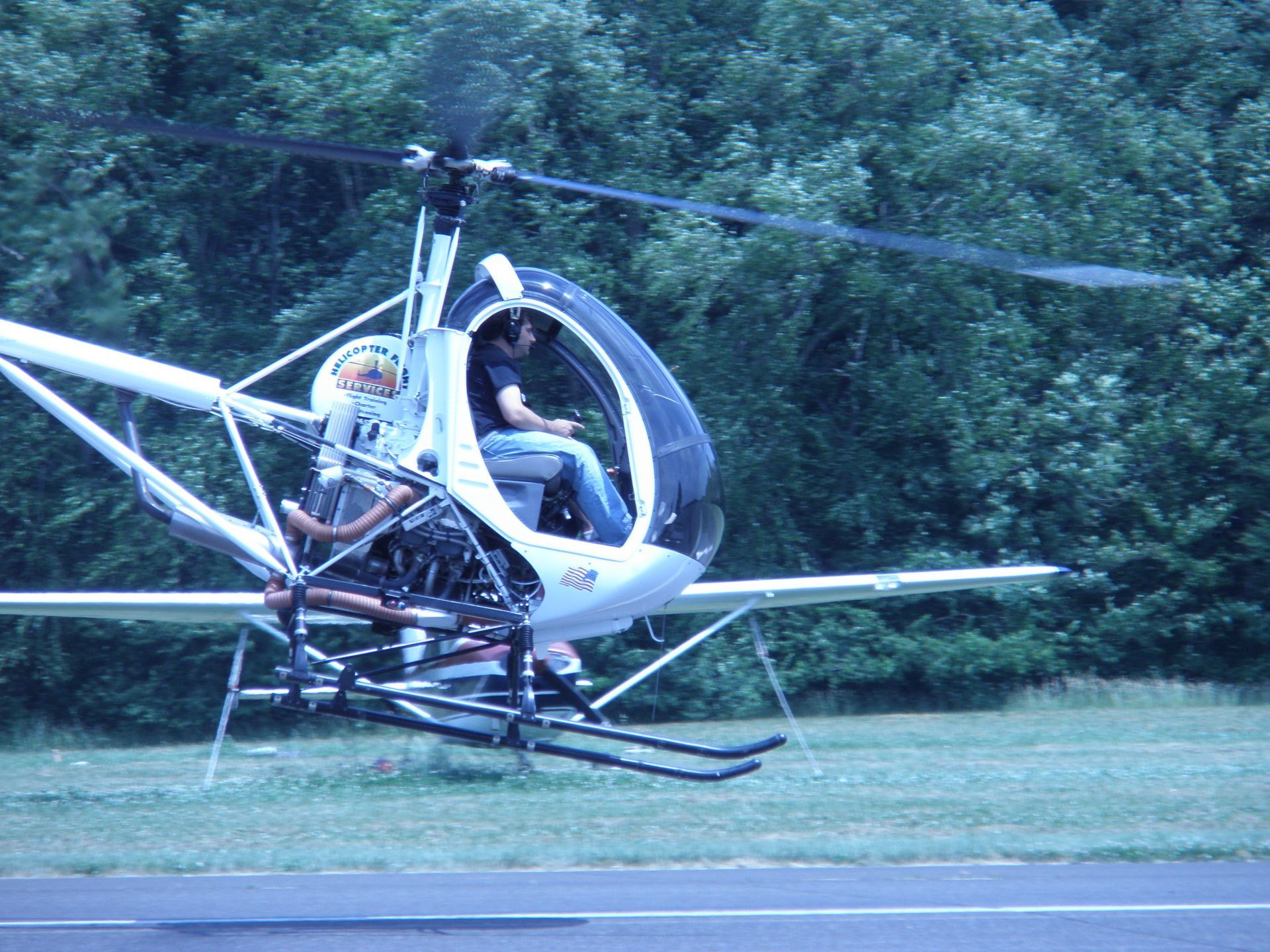 a small helicopter is flying over a grassy field