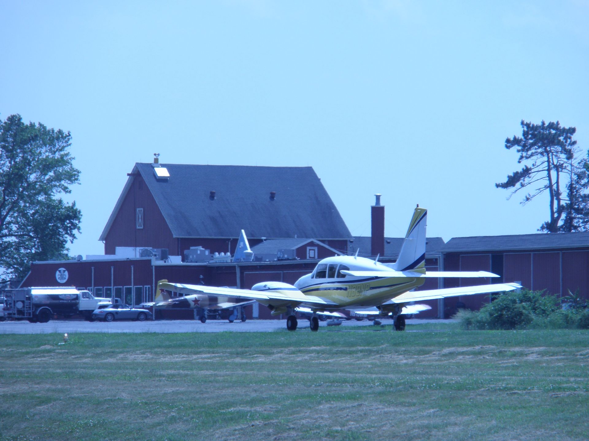 a yellow and white plane is parked in front of a building