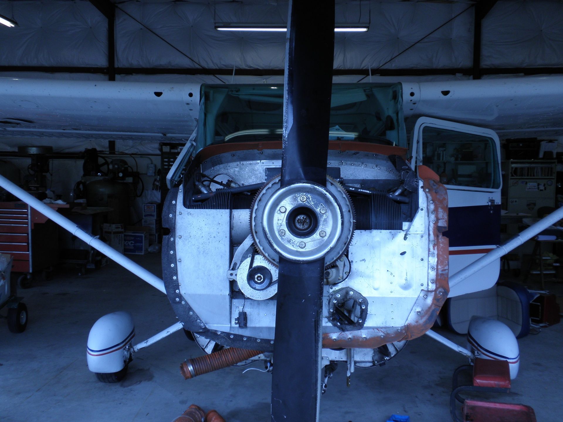 a small propeller plane is being worked on in a garage