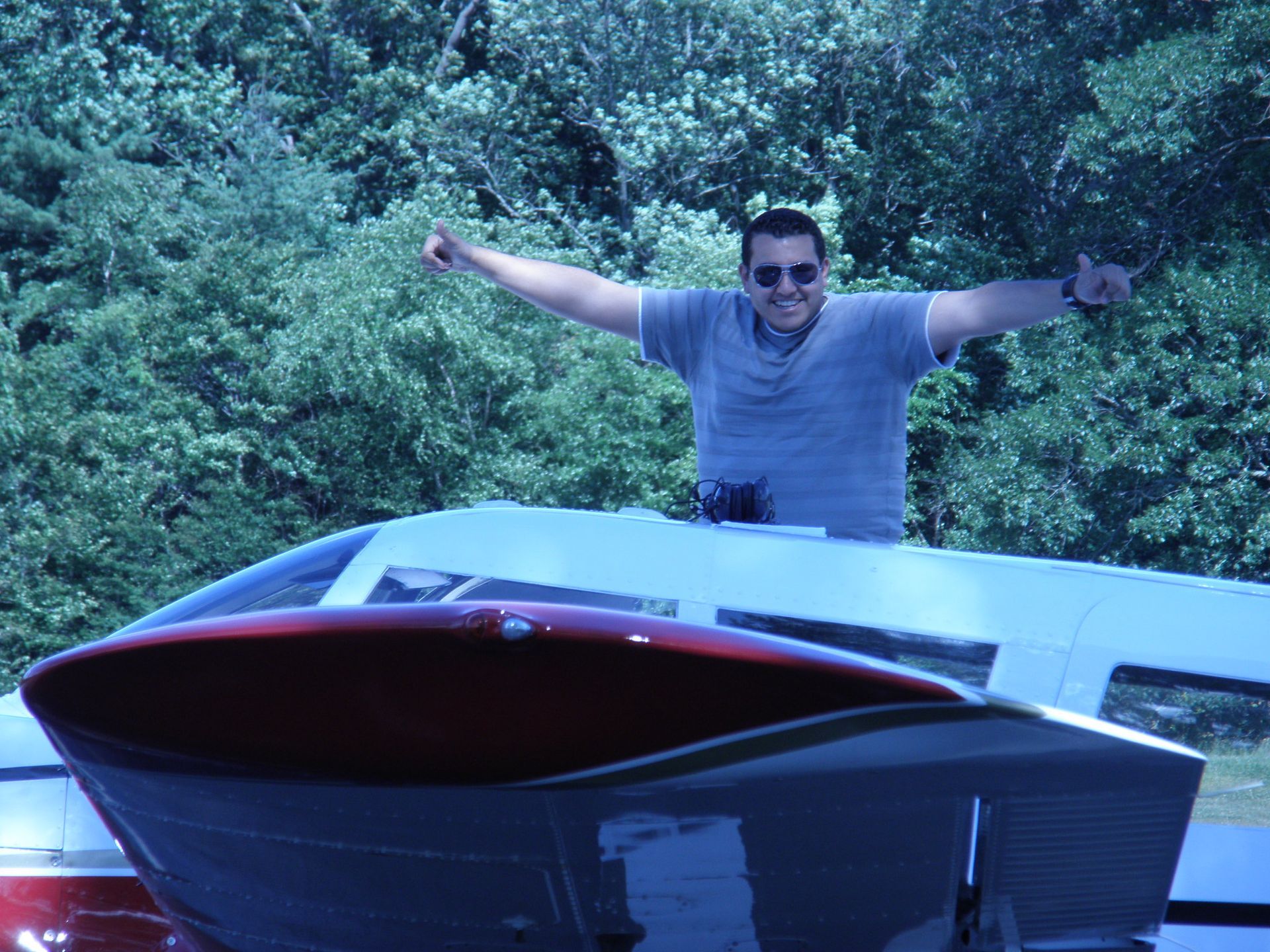 a man standing on top of an airplane with his arms outstretched