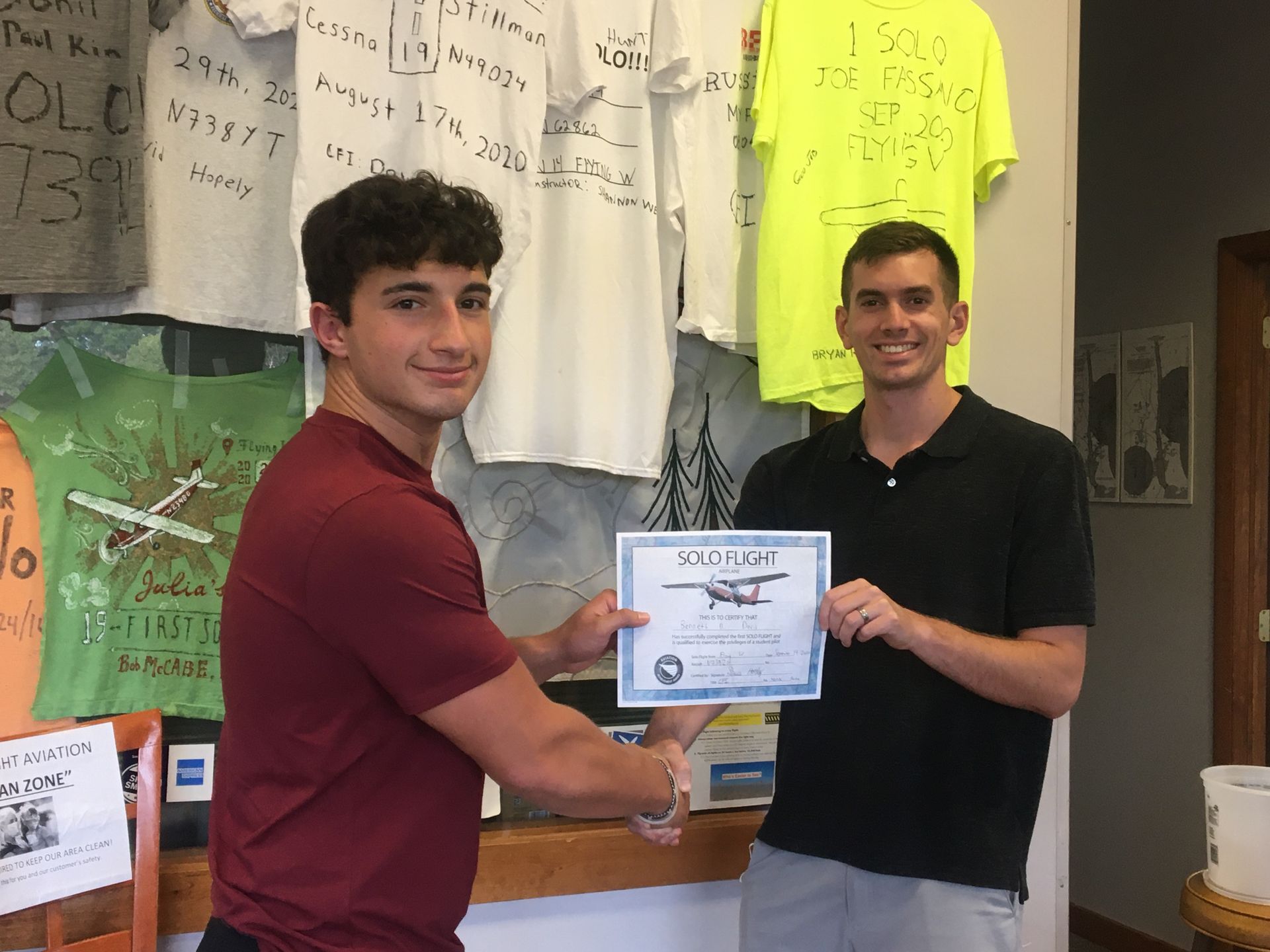 two men are shaking hands and one is holding a certificate