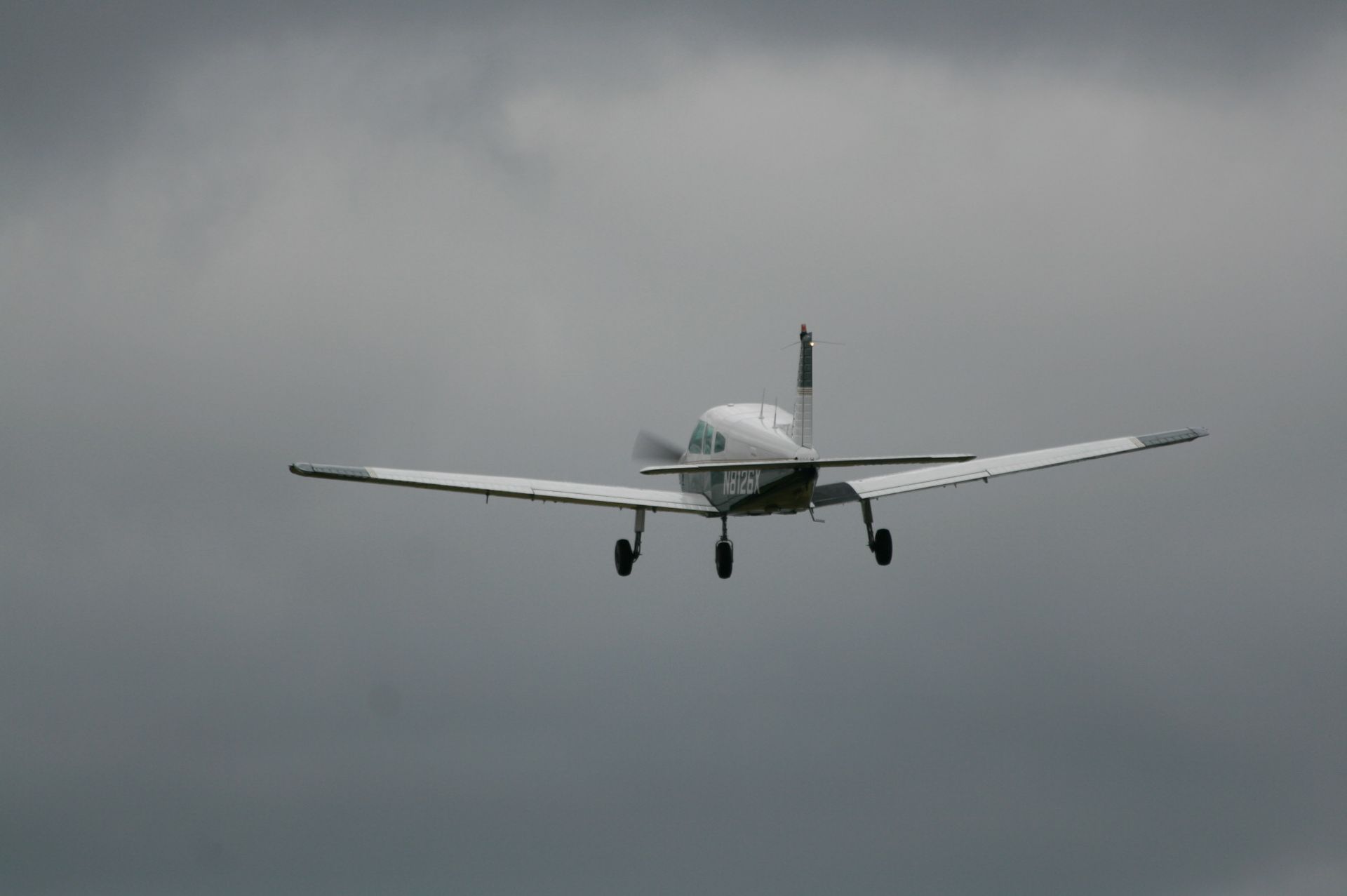 a small plane is flying through a cloudy sky