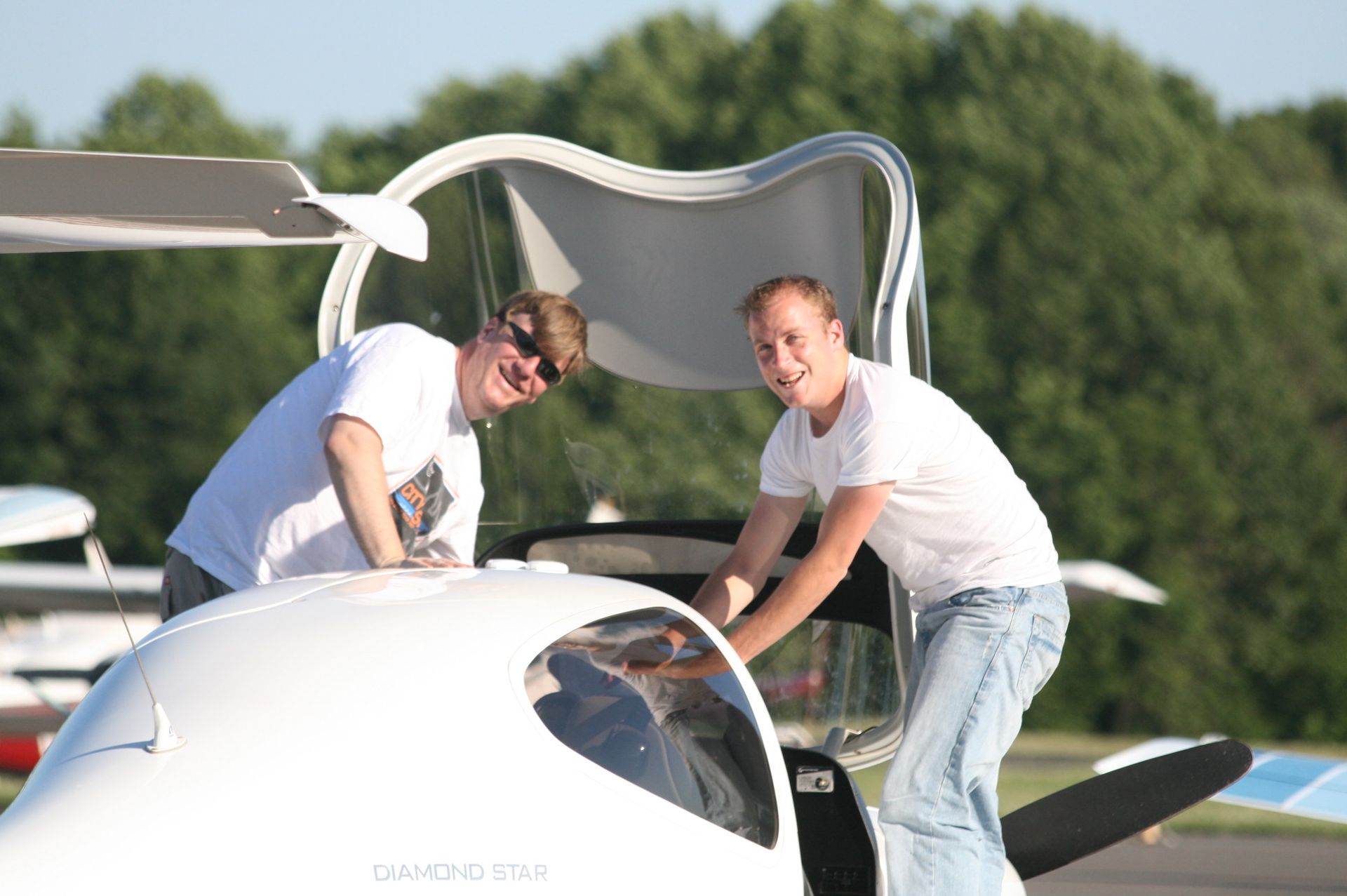 two men are working on an airplane with the hood open