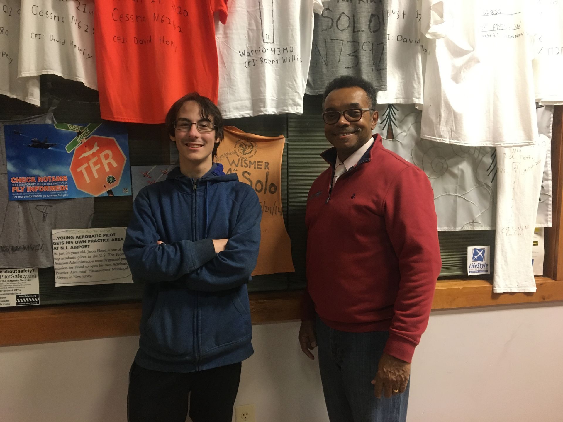 two men are standing next to each other in front of a display of t-shirts