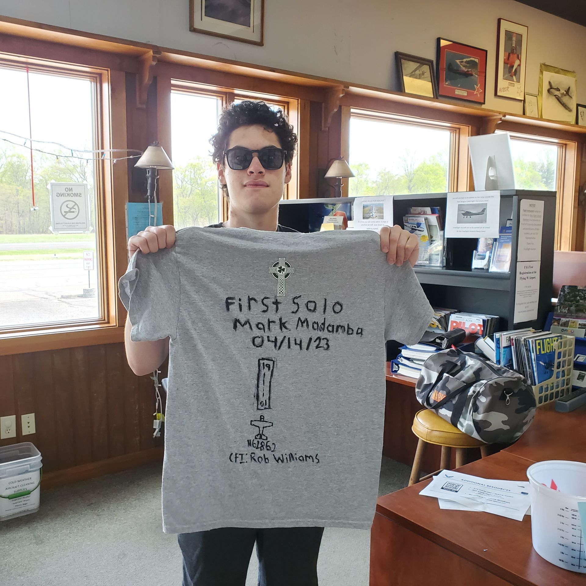 a man is holding up a t-shirt that says first solo