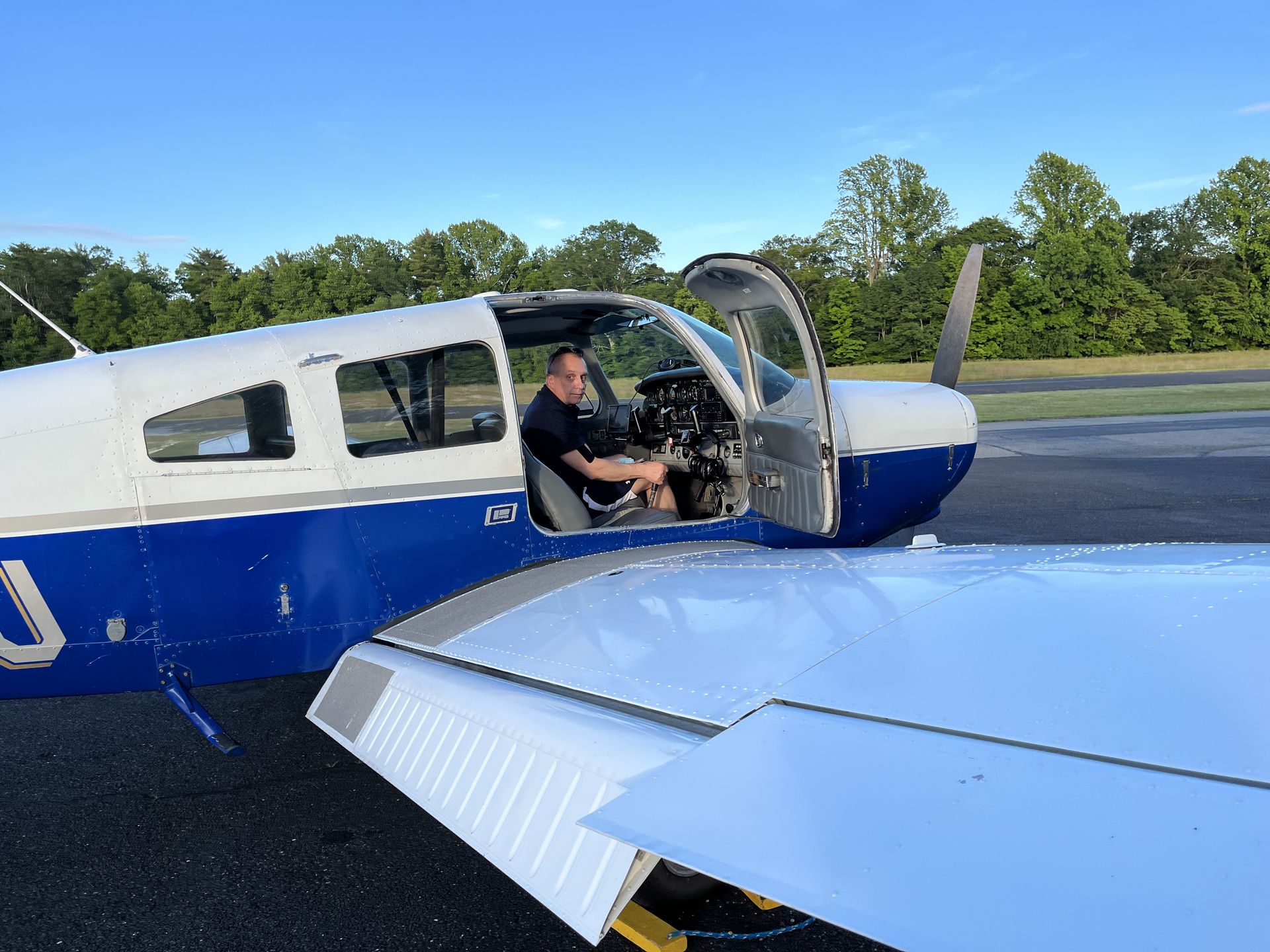 a man is sitting in the cockpit of a small blue and white plane
