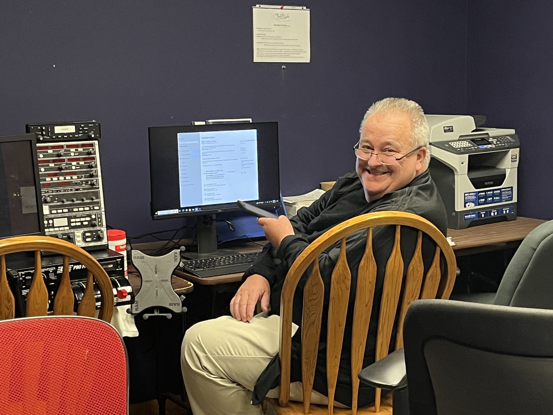 a man is sitting in front of a computer and smiling