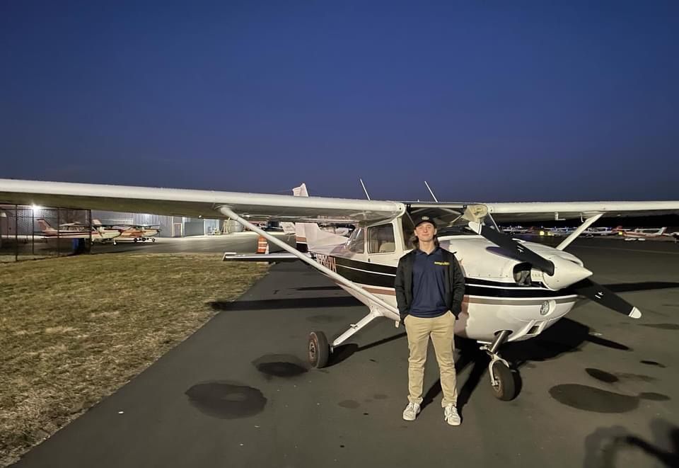 a man is standing in front of a small plane on a runway