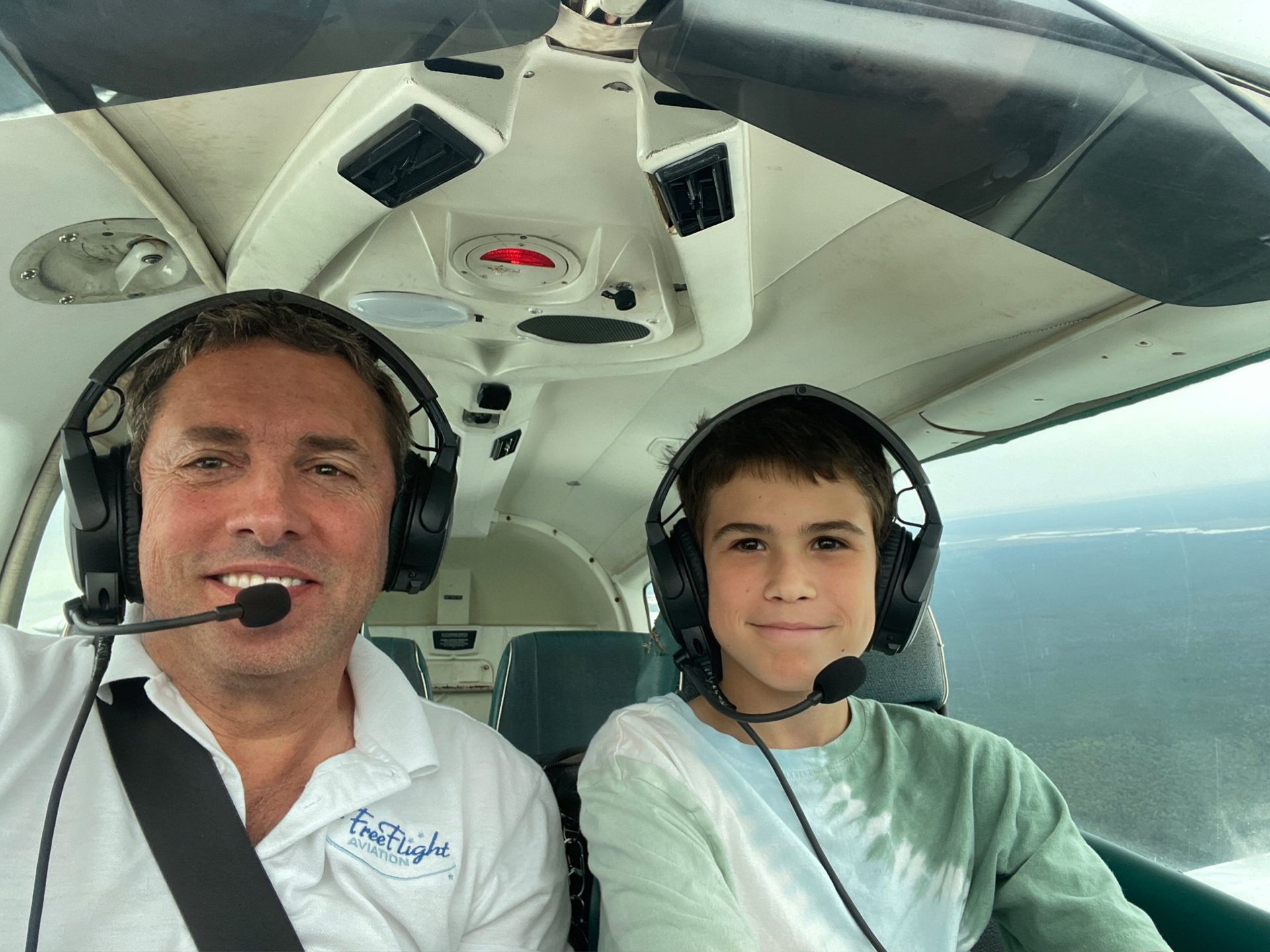 a man and a boy wearing headphones in a plane
