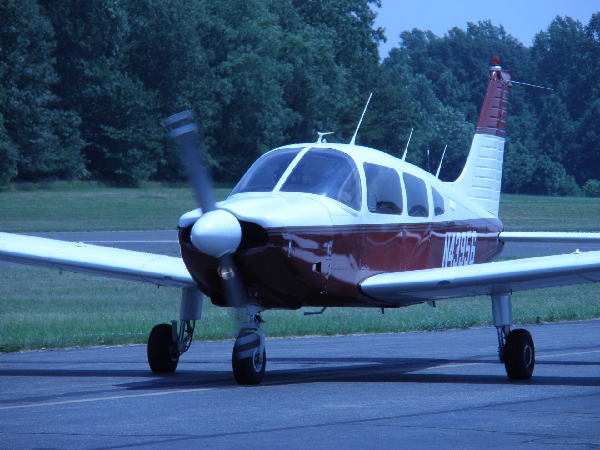 a small red and white propeller plane with the letters n358 on the tail