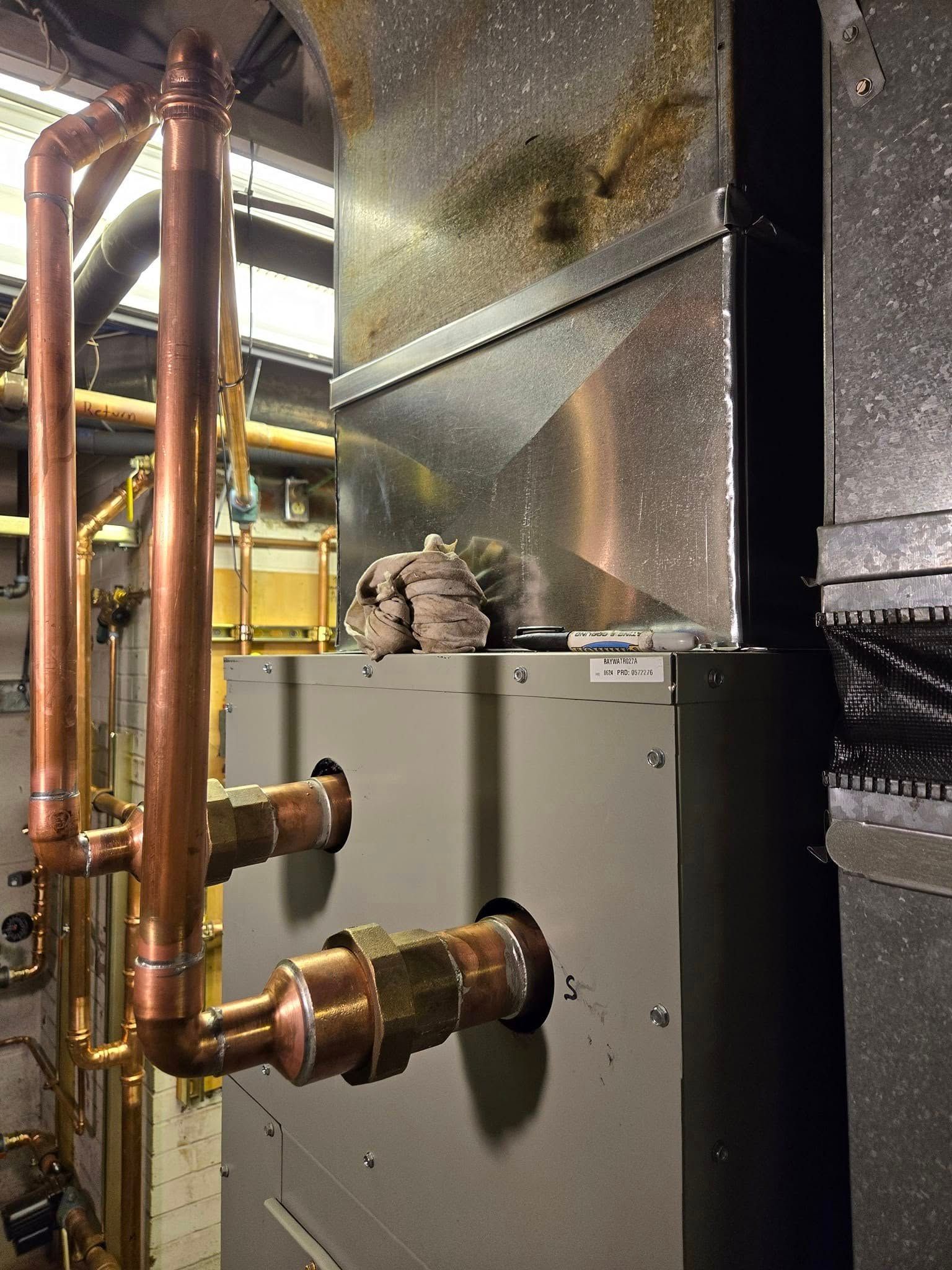 Copper pipes and HVAC unit in an industrial setting.