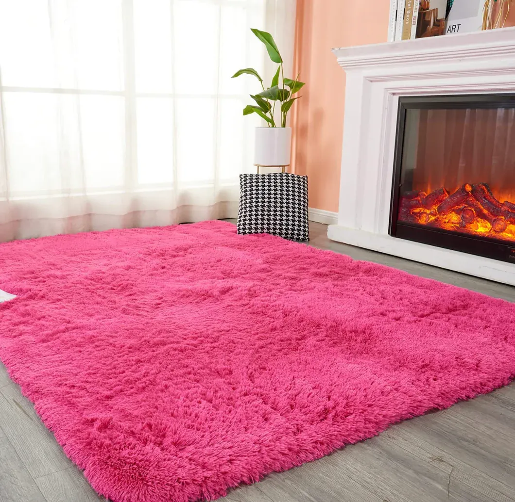 A living room with a pink rug and a fireplace.