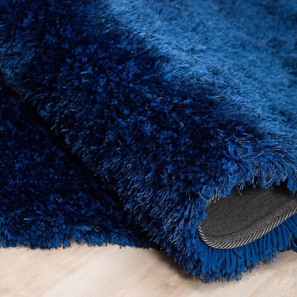 A close up of a blue rug on a wooden floor.