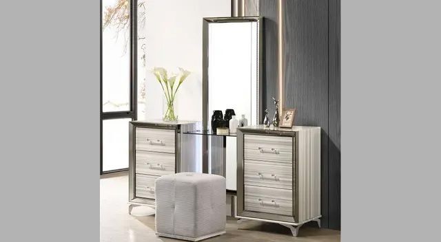 A bedroom with a dresser, mirror, and ottoman.