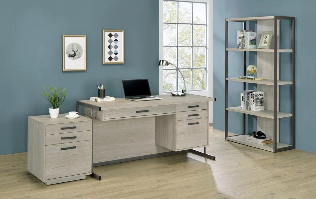 There is a desk with a laptop on it in the room.