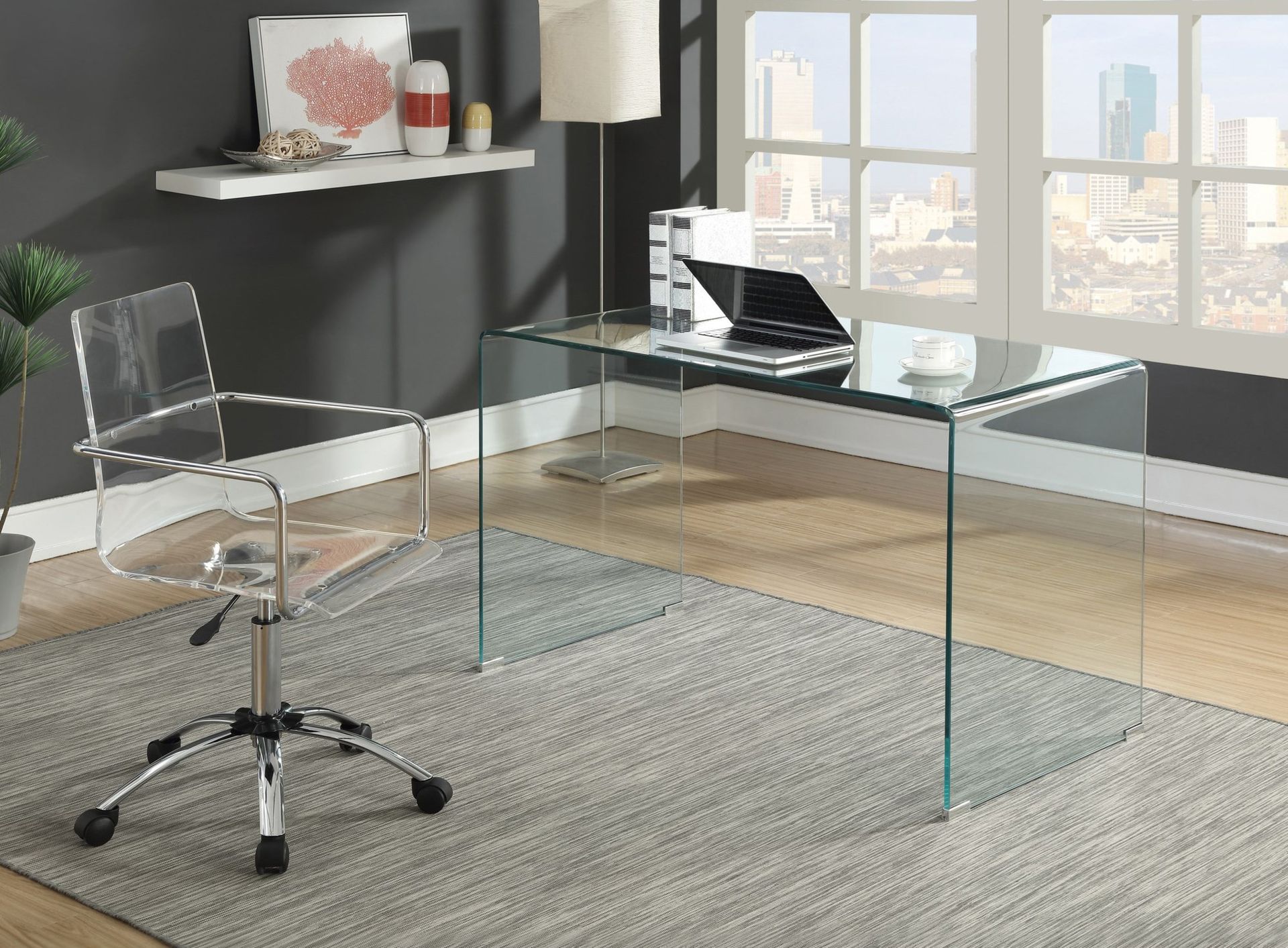 A clear office chair is sitting in front of a glass desk.