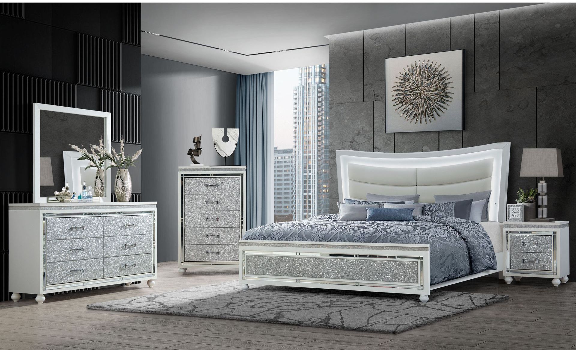 A bedroom with a bed , dresser , nightstand and mirror.