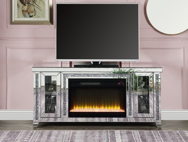 A television is sitting on top of a mirrored entertainment center with a fireplace.