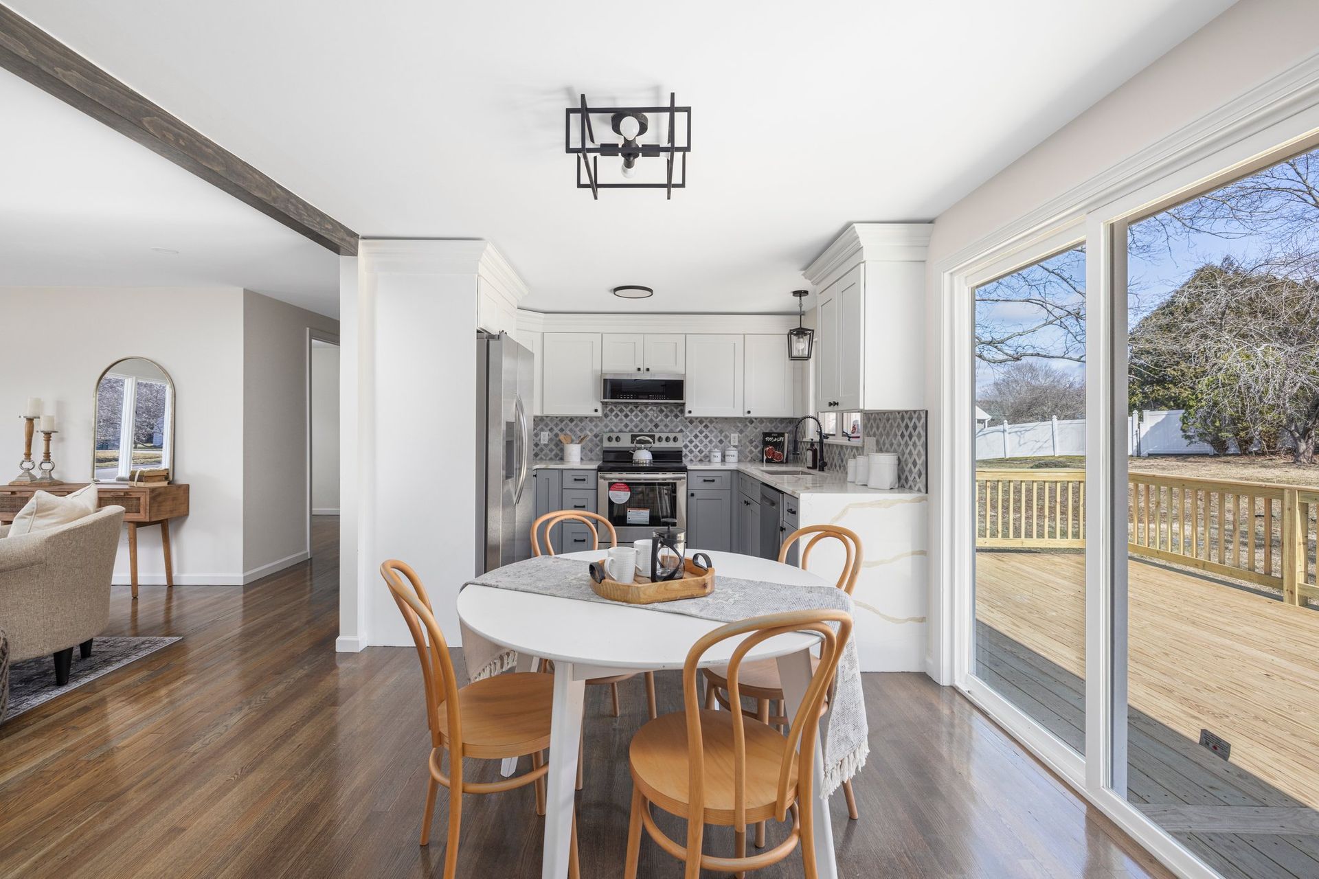 Kitchen and dining area with round table, wooden chairs, and sliding glass doors to a deck.