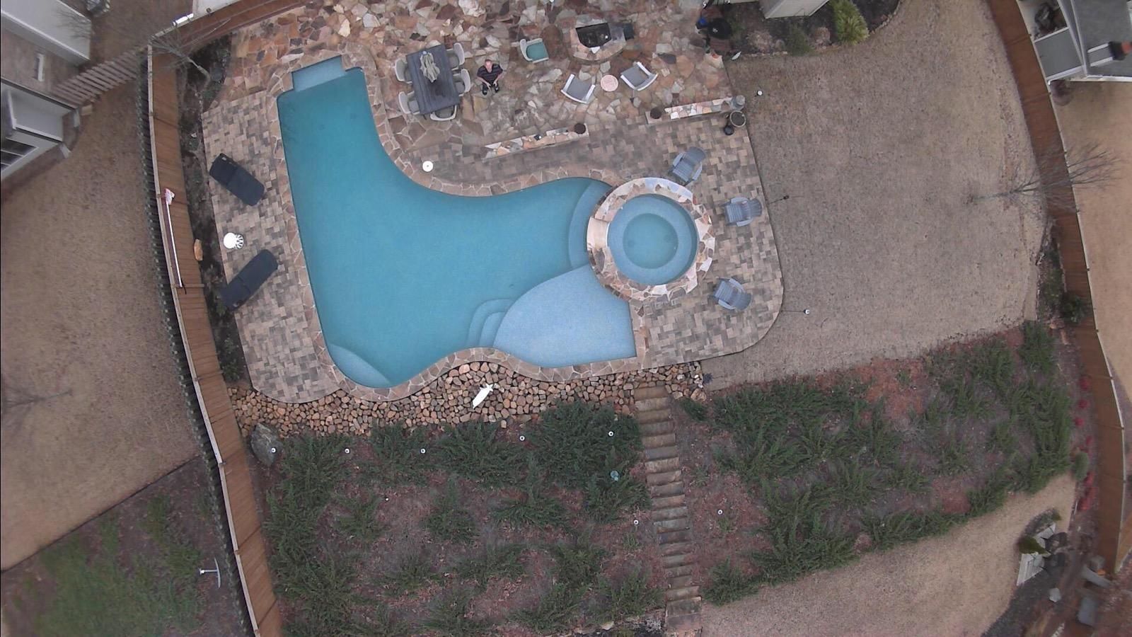 An aerial view of a swimming pool in a backyard.