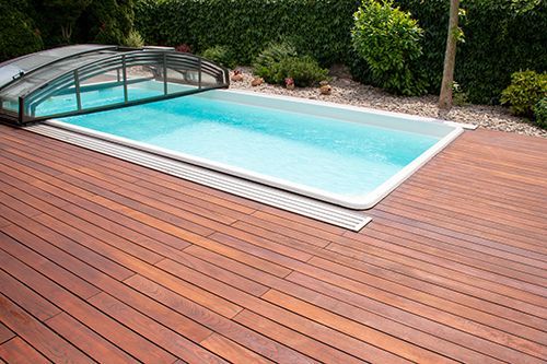 A swimming pool is surrounded by a wooden deck.