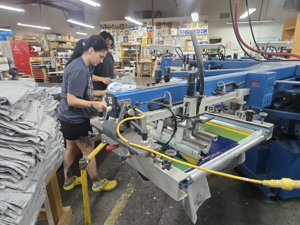 Shirt Stop employees screen print an order of customized T-shirts on one of the presses onsite on Friday, Oct. 3, 2025. (Photo by Breeanna Jent/The Gazette)