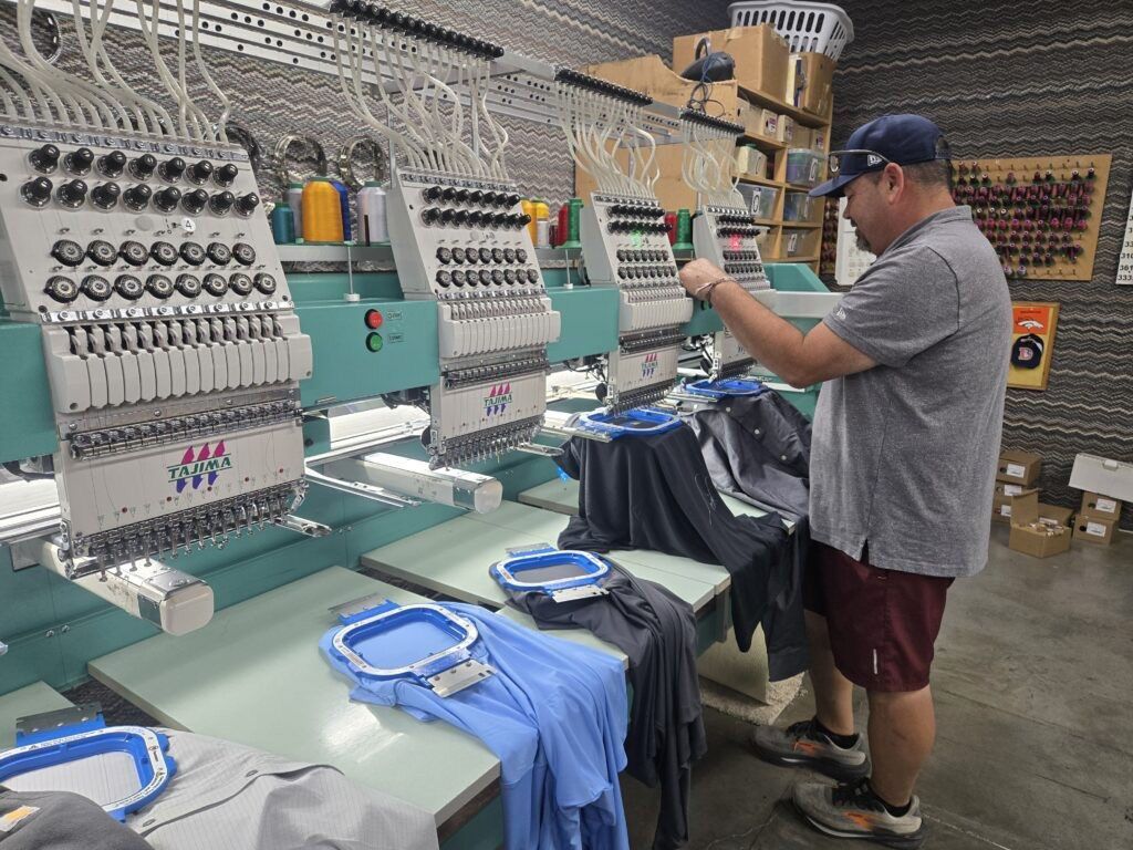 Shirt Stop employee Eric Davenport oversees the custom embroidery of an order on Friday, Oct. 3, 2025. (Photo by Breeanna Jent/The Gazette)