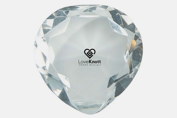 A heart shaped crystal with a love knott logo on it