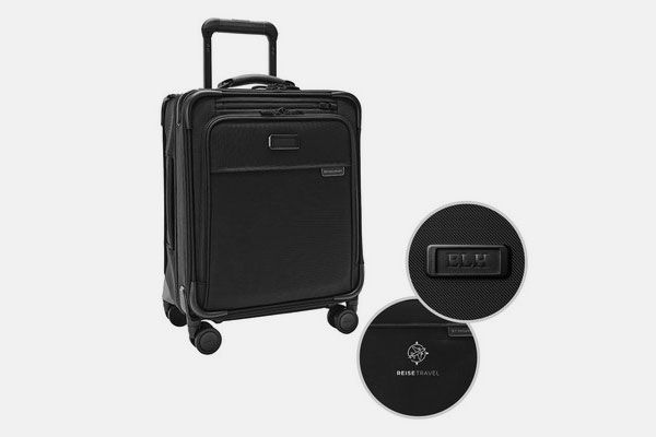 A black suitcase is sitting on a white surface.