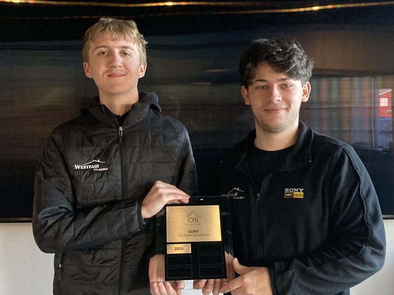 Two young men are standing next to each other holding a plaque.