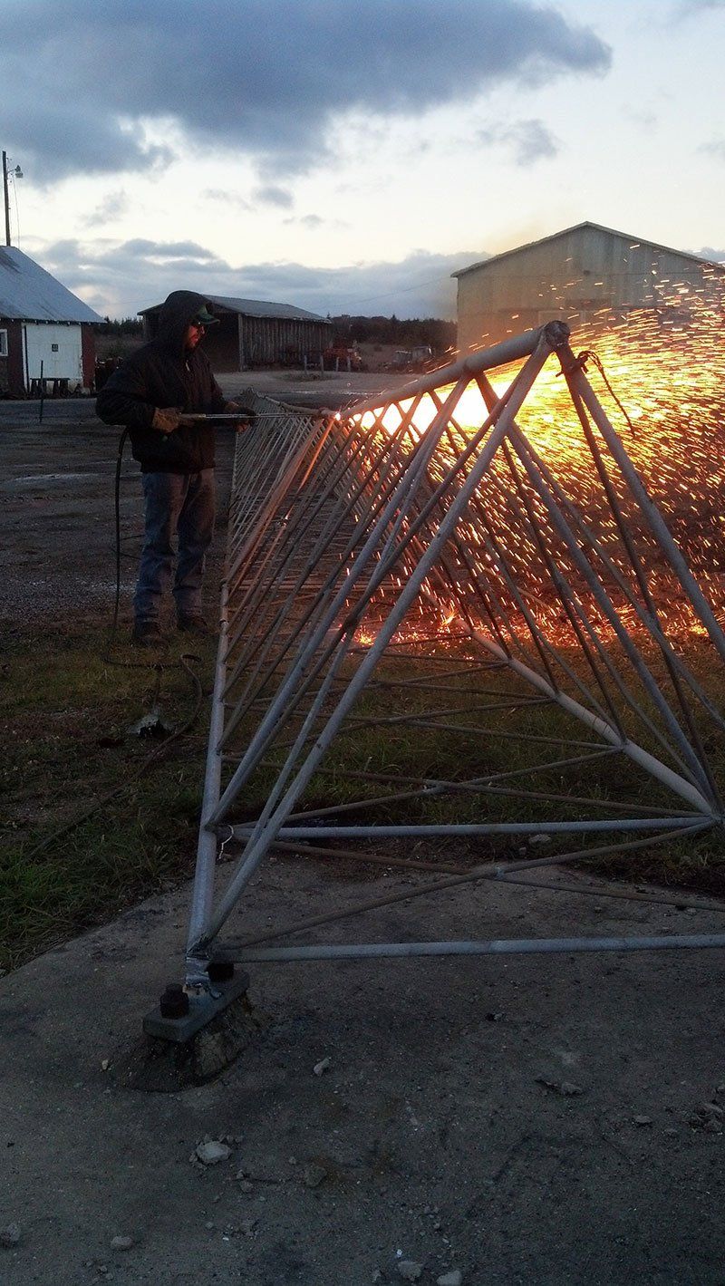 a crew member working on the high metal tower on the ground