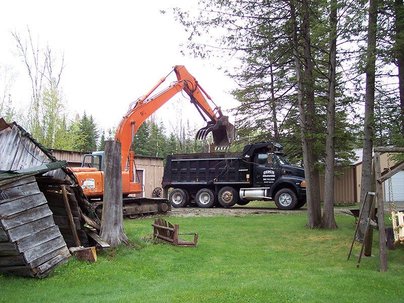 equipment demolishing the small cabin