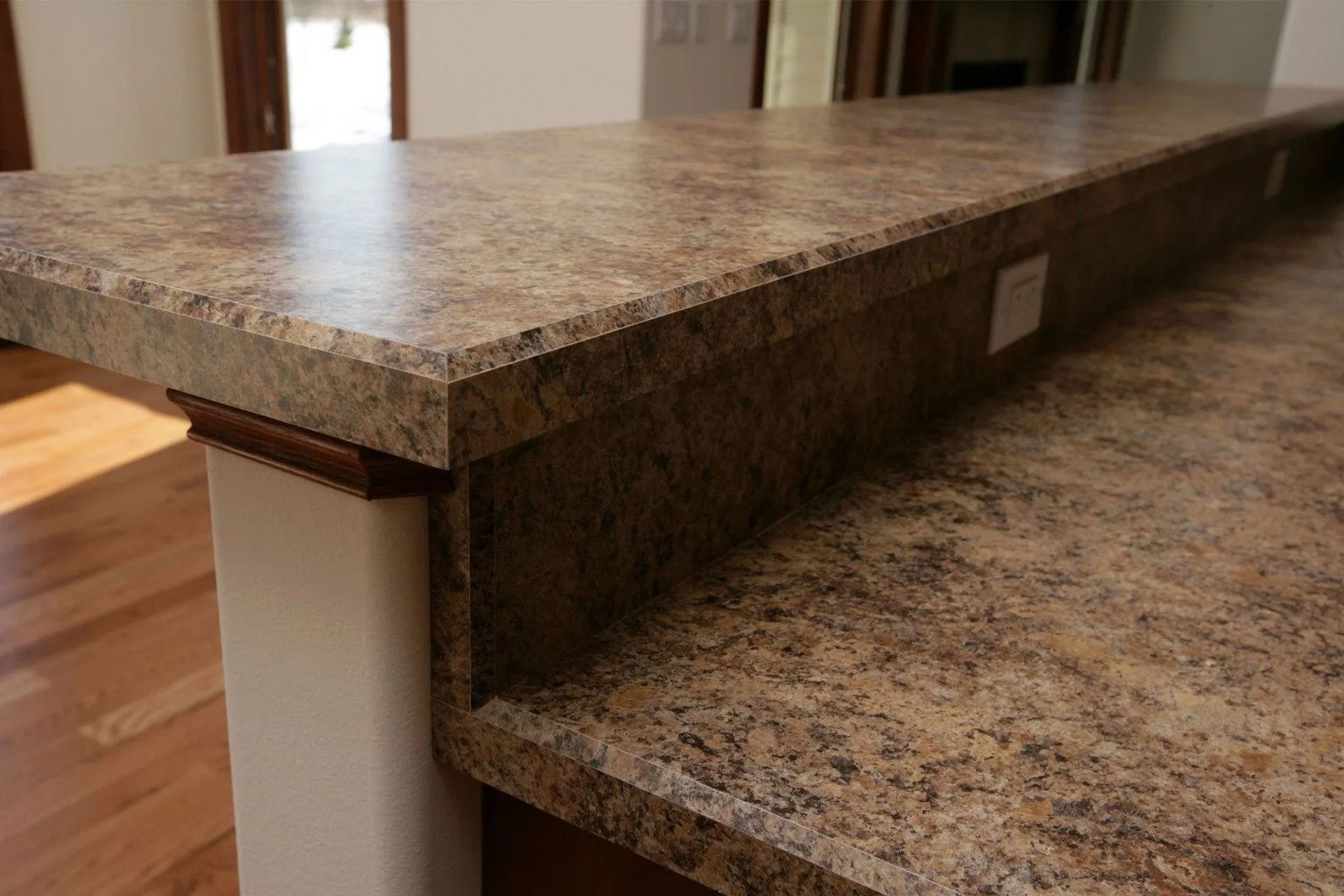 Brown and tan countertop with a textured finish, set on a white support.
