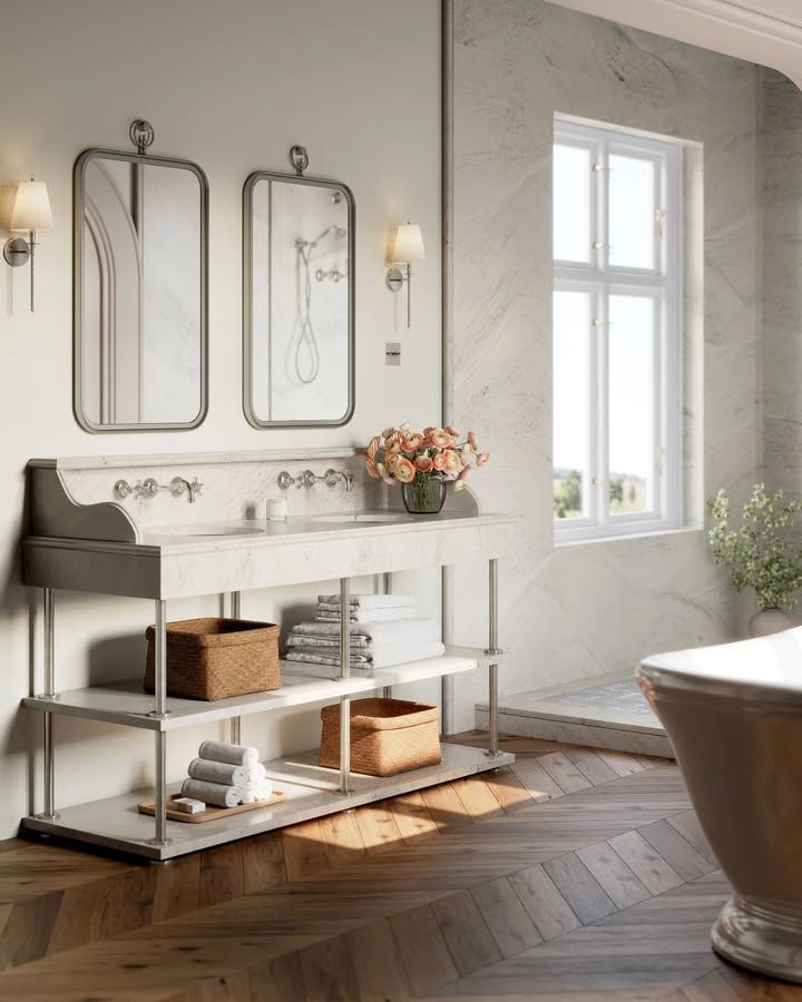 Elegant bathroom with marble vanity, framed mirrors, and herringbone wood floor.