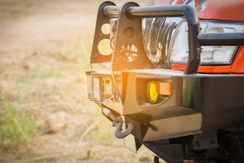 A close up of a bumper on a truck in a field.