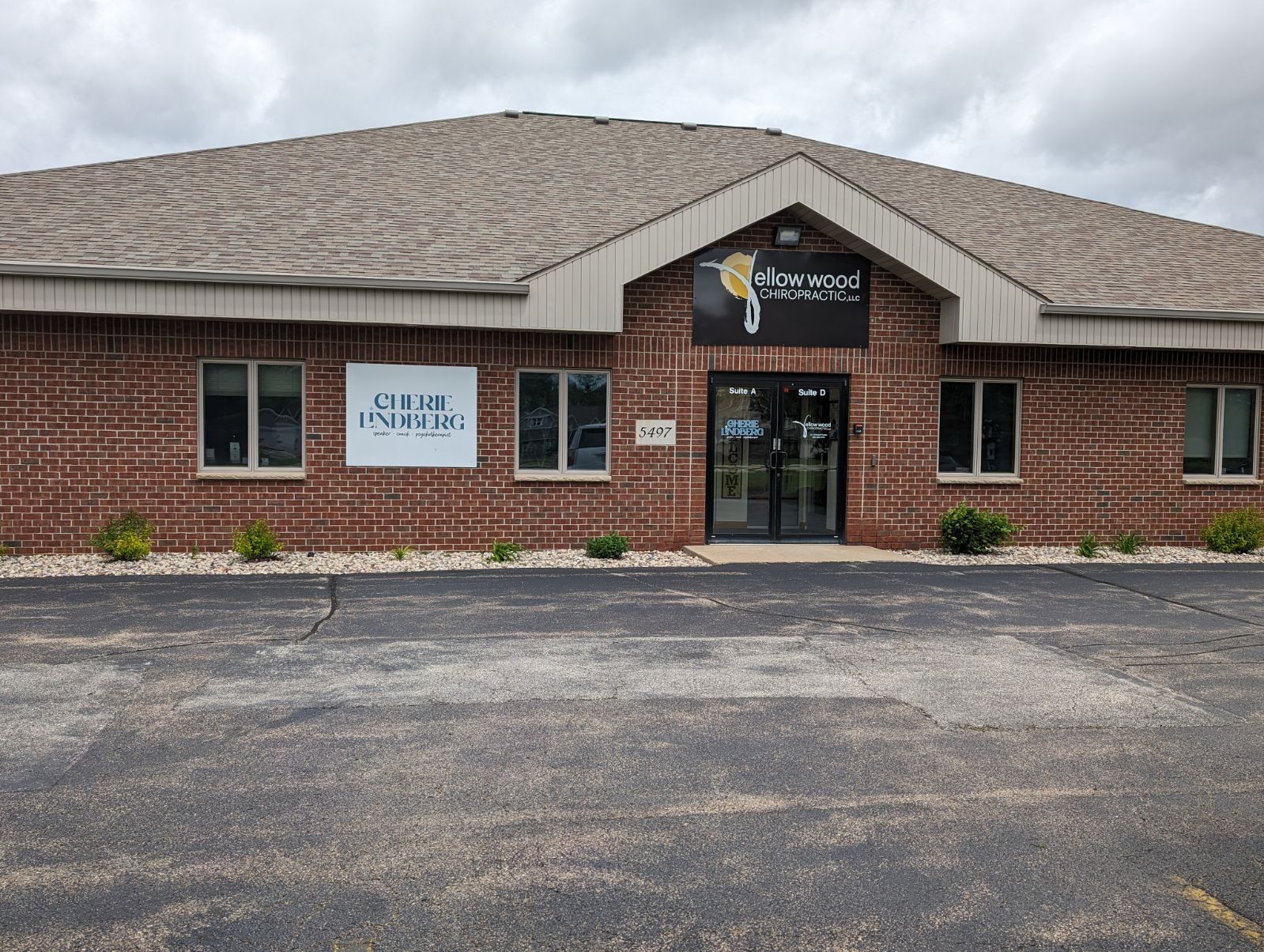 A large brick building with a parking lot in front of it.