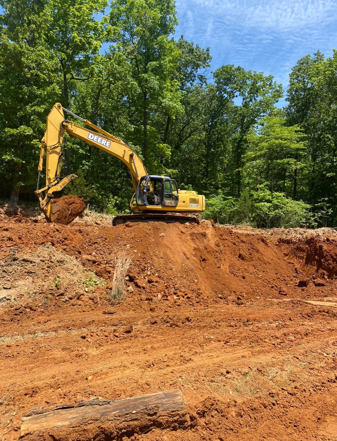 A yellow excavator is digging a hole in the dirt.