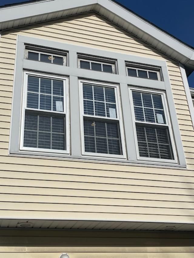 A house with three windows on the side of it