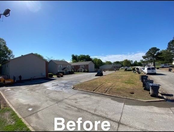 Wide suburban driveway and lawn with homes and parked cars under a clear blue sky, labeled “Before”